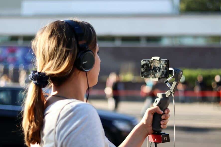 A girl recording videos on the street.