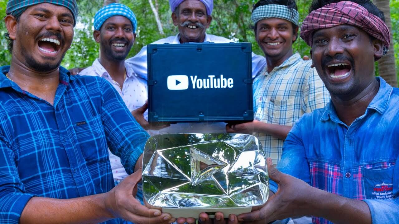 4 Indian people are together showing their youtube icon while they are happy